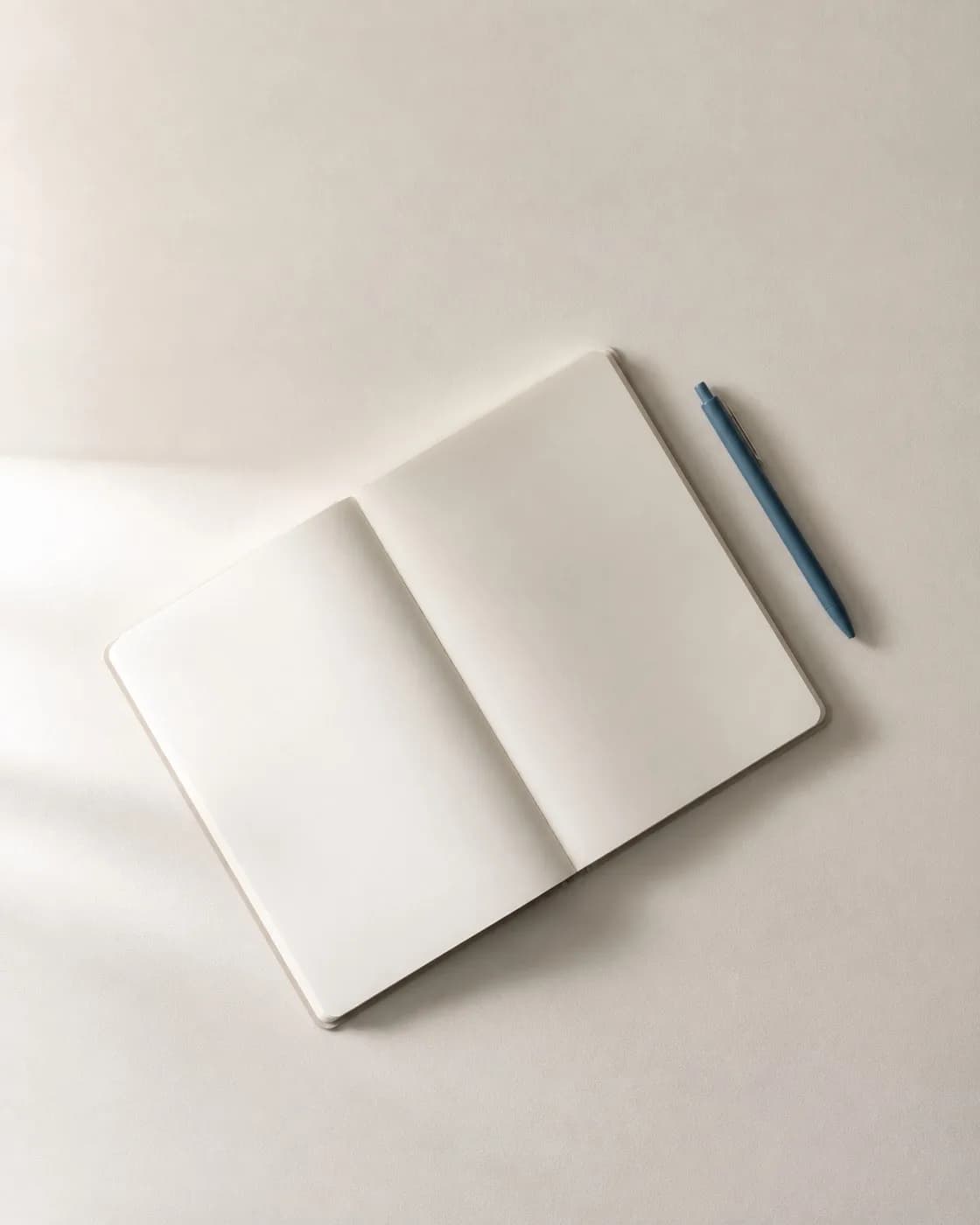 Un cuaderno abierto con una pluma encima.